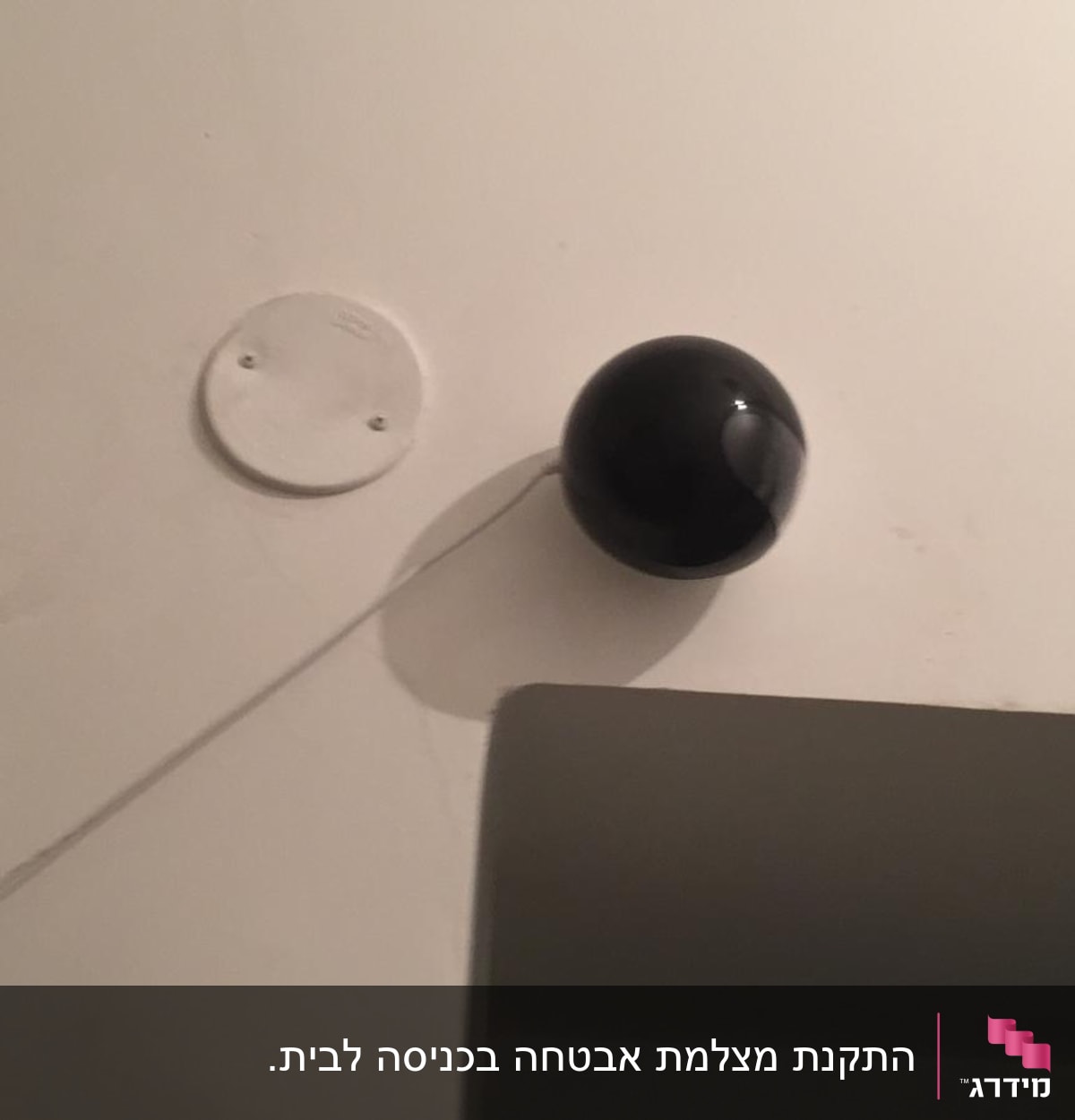 כדור שחור מחובר לקיר עם כבל לבן